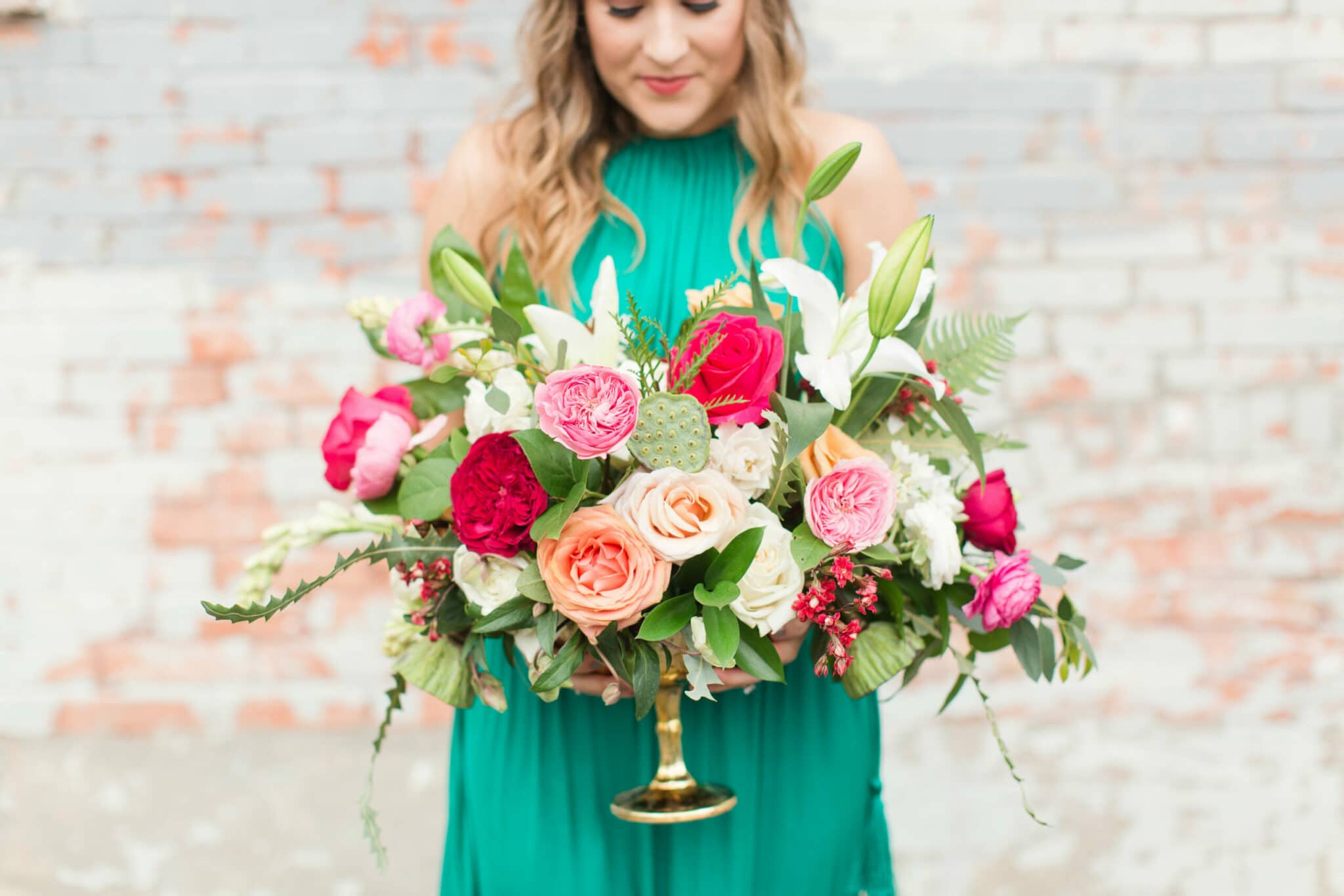 Girl in green dress holding brightly colored floral bouquet
