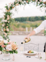 Wedding table set-up with waiter pouring wine into a glass