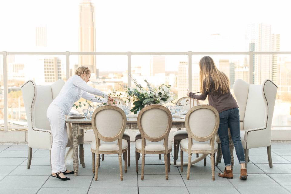 Wedding planners arranging a table at a styled shoot