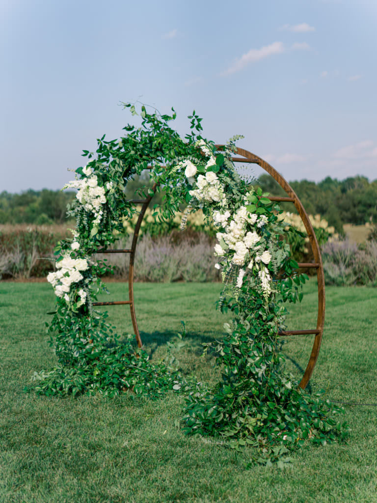 Circular wedding arch with ivory florals and greenery intertwined