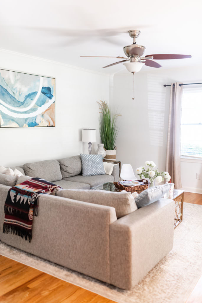 Living room with sofa, lamp, pictures and plants in the Chris and Sarah Chancey's family home in Atlanta