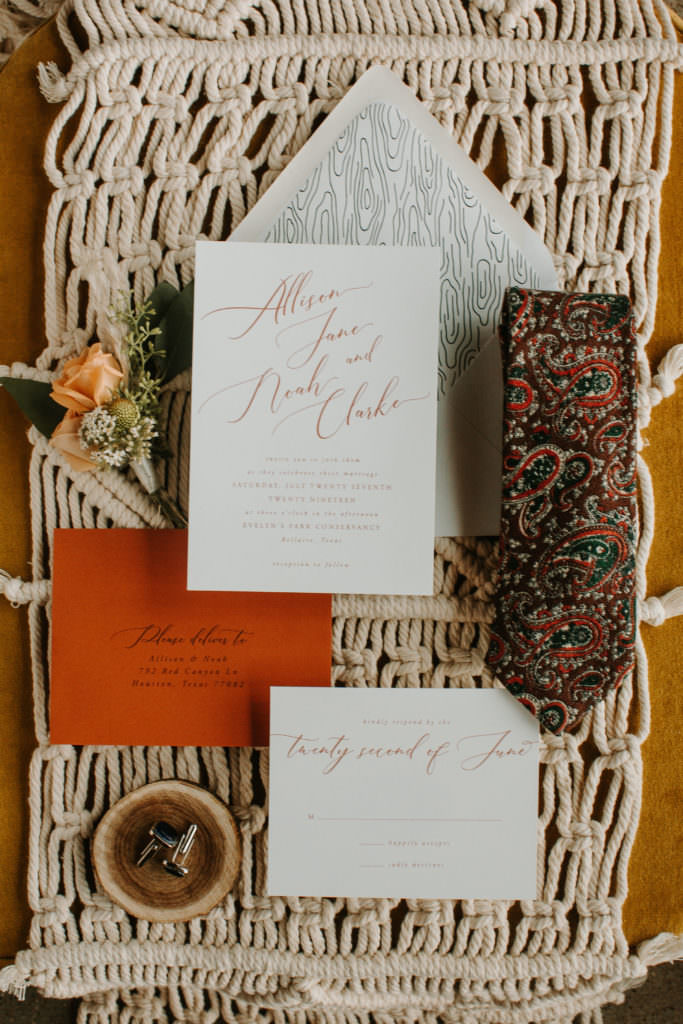 wedding invite flatlay with burnt orange envelope