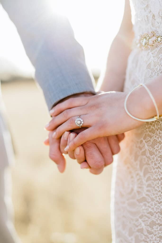 couple holding hands, engagement ring