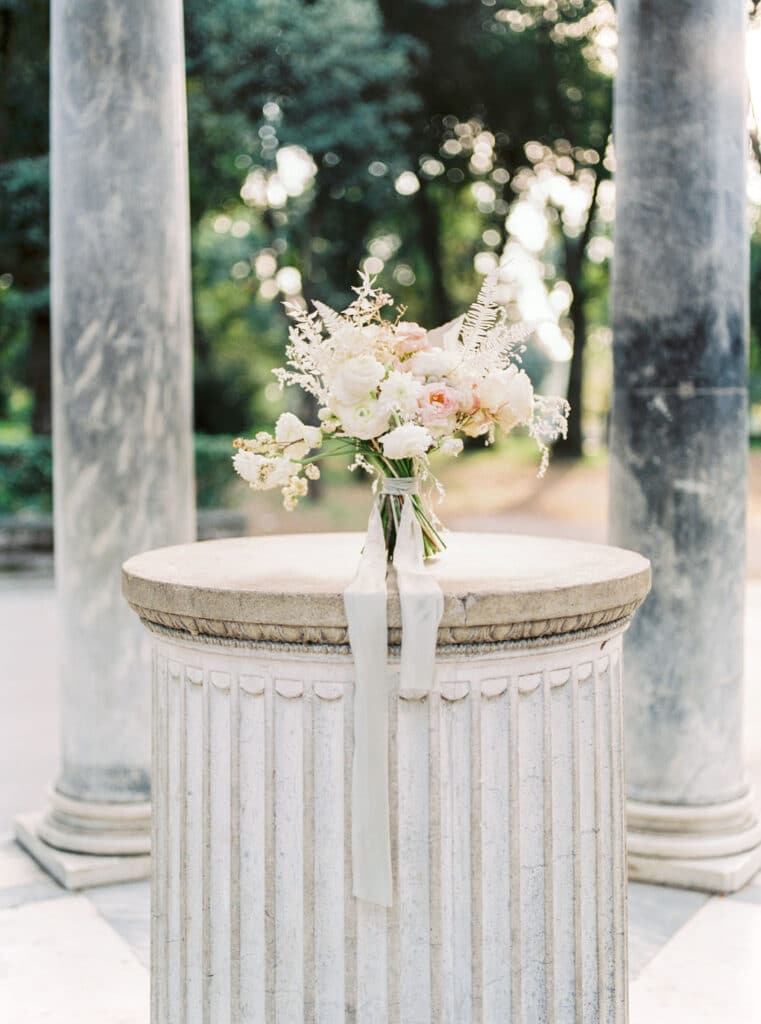 Bouquet of flowers send on a concrete pillar in Rome, Italy. How to get married in Europe.