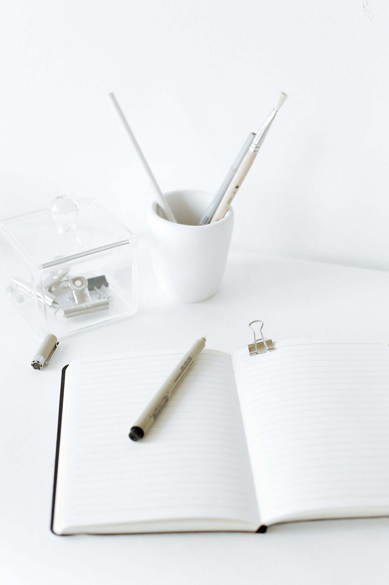 White notebook and pen pot. The ultimate guide to blogging for wedding pros.