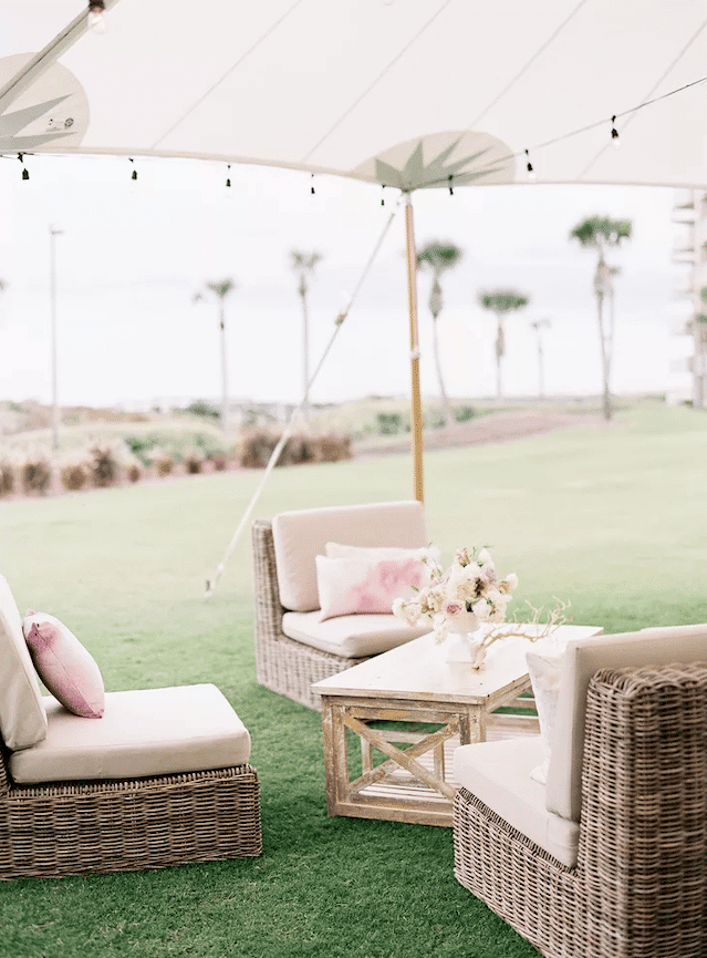 Comfy lounge chairs overlooking green lawn and palm trees at Rosemary Beach wedding